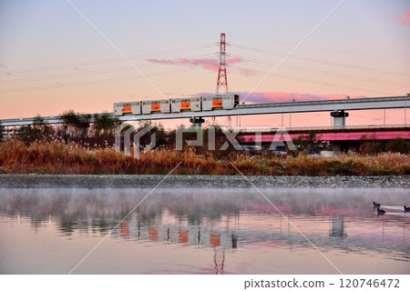 A clear morning sky and the Tama Monorail reflected on the river surface 120746472