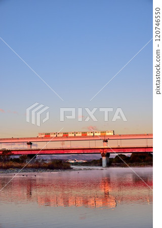 A clear morning sky and the Tama Monorail reflected on the river surface 120746550