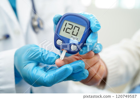 Asian doctor using digital glucose meter for check sample blood sugar level to treatment diabetes. Asian doctor using digital glucose meter for check sample blood sugar level to treatment diabetes. 120749587