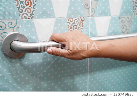 Asian elderly old woman patient use toilet support rail in bathroom, handrail safety grab bar, security in nursing hospital. 120749653