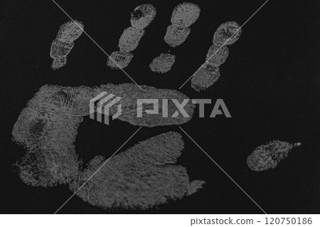 a print of a man's hand on a black sheet of paper 120750186