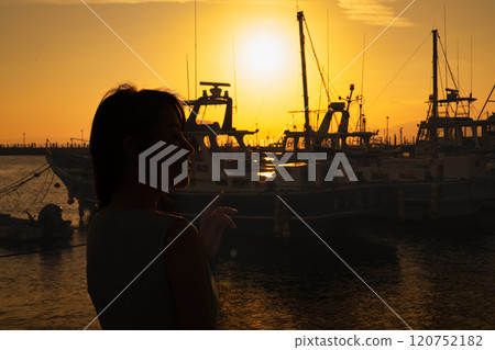 港口的日落和女人的剪影 120752182