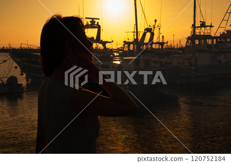 Sunset at the harbor and silhouette of a woman 120752184