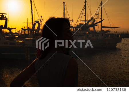 港口的日落和女人的剪影 120752186