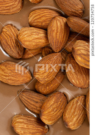 Almond nuts in melted milk chocolate macro 120754758