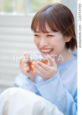 A young woman with a feminine look drinking tea A young woman with a feminine look drinking tea 120754769