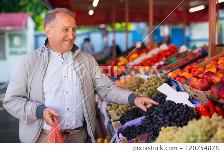 Man choosing fruits in market 120754878