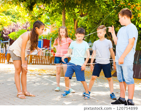 Girl walking through tangled rope while playing outside Girl walking through tangled rope while playing outside 120754899