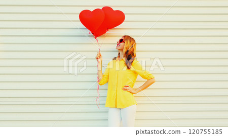 Beautiful happy smiling young woman with bunch of red heart shaped balloons on white background Beautiful happy smiling young woman with bunch of red heart shaped balloons on white background 120755185
