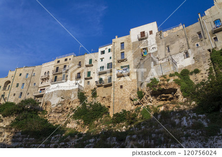 Traditional houses on dramatic cliffs rising from Adriatic sea in Polignano a Mare, Italy Traditional houses on dramatic cliffs rising from Adriatic sea in Polignano a Mare, Italy 120756024
