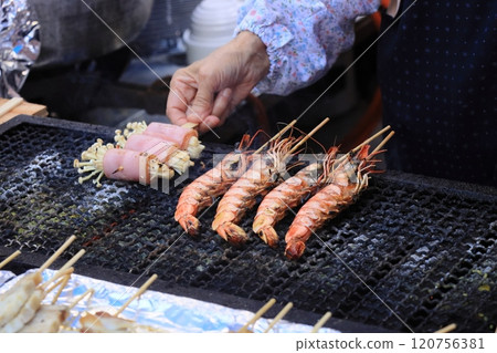 Hands grilling charcoal at a festival 120756381