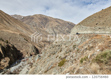 Gravel road in the mountainside. Travelling by car Gravel road in the mountainside. Travelling by car 120756460