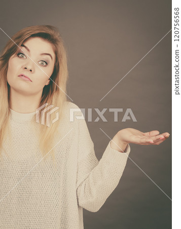 Confused young blonde woman gesturing with hands 120756568