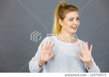 Scared woman gesturing stop gesture with hands 120756575