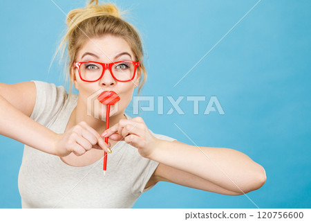 Happy woman holding fake lips on stick Happy woman holding fake lips on stick 120756600