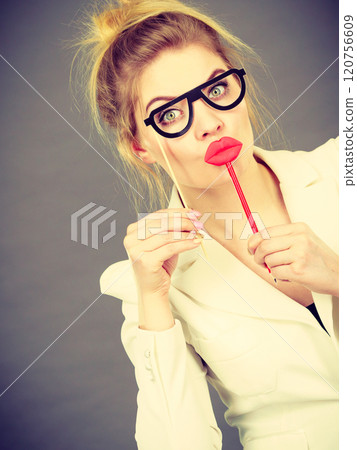 Happy elegant woman holding carnival accessoies on stick Happy elegant woman holding carnival accessoies on stick 120756609