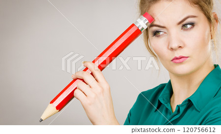 Woman confused thinking, big pencil in hand 120756612