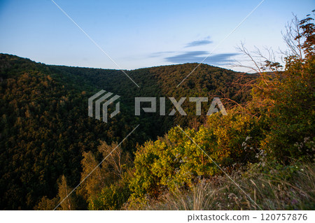 Majestic hills embrace the tranquil valley at sunset in a peaceful wilderness setting 120757876