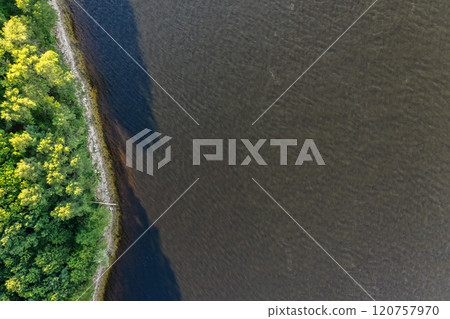 Serene view of Vilga River shoreline amidst lush greenery at golden hour 120757970