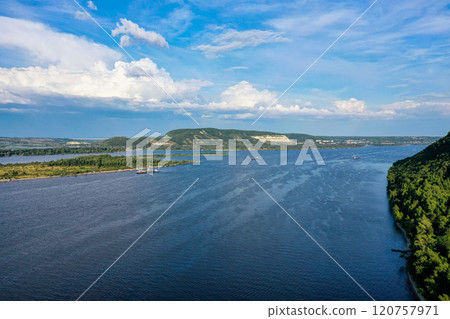 Majestic views of the Vilga river and the surrounding lush landscape under a vibrant sky Majestic views of the Vilga river and the surrounding lush landscape under a vibrant sky 120757971