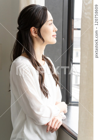 A woman looking out the window A woman looking out the window 120758609