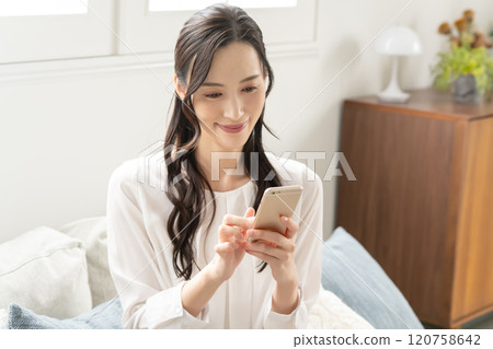 Woman operating a smartphone Woman operating a smartphone 120758642