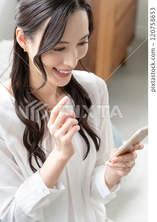 Woman operating a smartphone Woman operating a smartphone 120758653