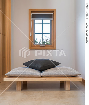 Minimalist seating space with wooden platform and cushions by a window overlooking nature Minimalist seating space with wooden platform and cushions by a window overlooking nature 120758860