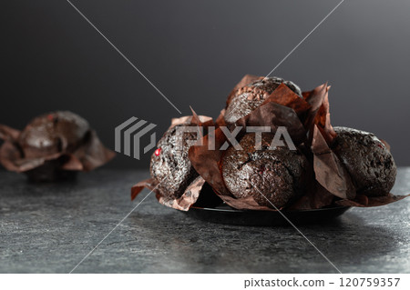 Dark chocolate muffins on a black table. Dark chocolate muffins on a black table. 120759357