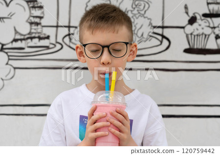 A boy drinks a milkshake cocktail through straws 120759442