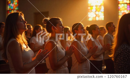 Congregants attend a worship service in a warmly lit church 120760167