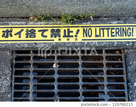 A notice prohibiting littering has been posted in the roadside gutters A notice prohibiting littering has been posted in the roadside gutters 120760213