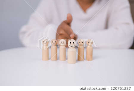 World mental health day, Think positive, Good emotion, Positive attitude leadership, Hand choosing happy smiling wooden figure from unhappy. Excellent feedback and customer satisfaction concept. World mental health day, Think positive, Good emotion, Positive attitude leadership, Hand choosing happy smiling wooden figure from unhappy. Excellent feedback and customer satisfaction concept. 120761227