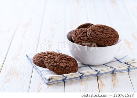 Chocolate brownie cookies with cracks in a ceramic bowl on a white table, selective focus. 120761587