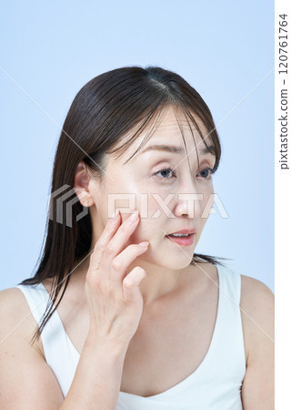 一位中年婦女一臉疲憊地做皮膚護理 120761764
