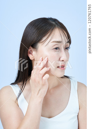 一位中年婦女一臉疲憊地做皮膚護理 120761765