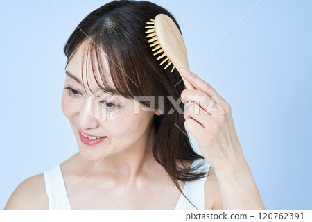 A middle-aged woman brushing her hair 120762391