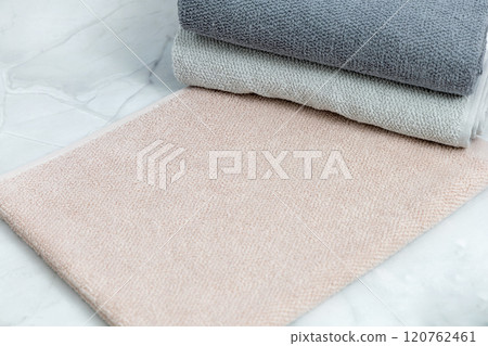 Folded clean towels on white marble background. Folded clean towels on white marble background. 120762461