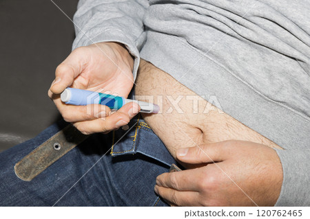 Diabetic man injects himself with Ozempic Insulin injection pen for diabetics. 120762465