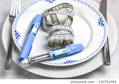 Ozempic Insulin injection pen or insulin cartridge pen for diabetics on a white plate. Ozempic Insulin injection pen or insulin cartridge pen for diabetics on a white plate. 120762469