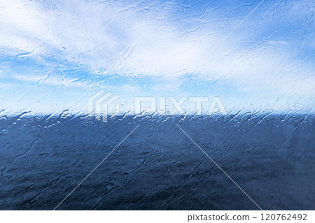 Raindrops on the window overlooking the sea. Background with sea and sky on a rainy day. 120762492