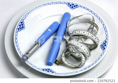 Ozempic Insulin injection pen or insulin cartridge pen for diabetics on a white plate. 120762521