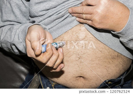 Diabetic man injects himself with Ozempic Insulin injection pen for diabetics. Diabetic man injects himself with Ozempic Insulin injection pen for diabetics. 120762524