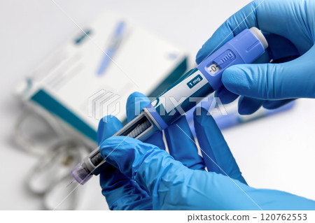 Hands in surgical gloves holding Ozempic Insulin injection pen for diabetics. 120762553
