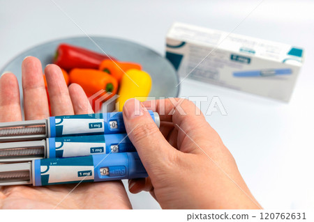 Hands holding Ozempic Insulin injection pen for diabetics and weight loss 120762631
