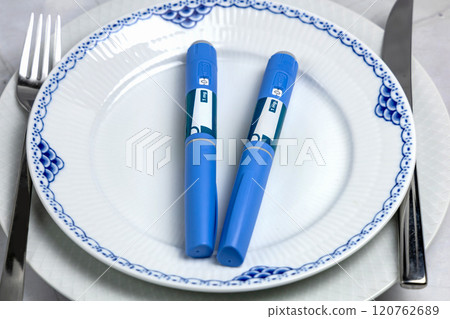 Ozempic Insulin injection pen or insulin cartridge pen for diabetics on a white plate. 120762689
