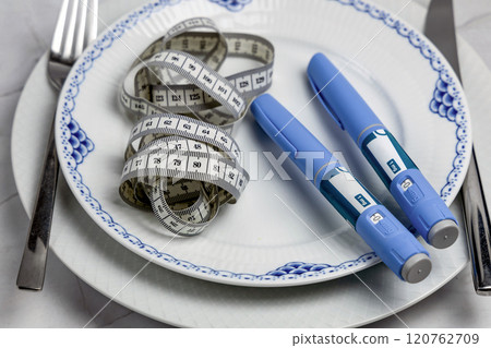Ozempic Insulin injection pen or insulin cartridge pen for diabetics on a white plate. 120762709
