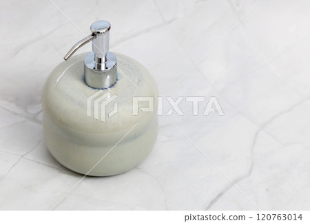 Ceramic soap dispenser and folded towel on white marble background. Ceramic soap dispenser and folded towel on white marble background. 120763014