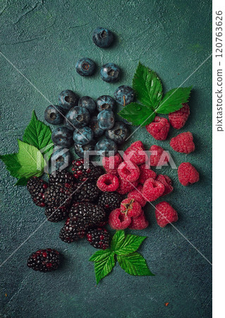 a mix of ripe berries, with leaves scattered on the table, raspberries, blackberries, blueberries, food background, a mix of ripe berries, with leaves scattered on the table, raspberries, blackberries, blueberries, food background, 120763626