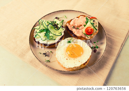 Assortment of sandwiches, white bread, fried egg, cream cheese and cucumber, capelin caviar, sesame bun, breakfast, on a white table, no people, 120763656